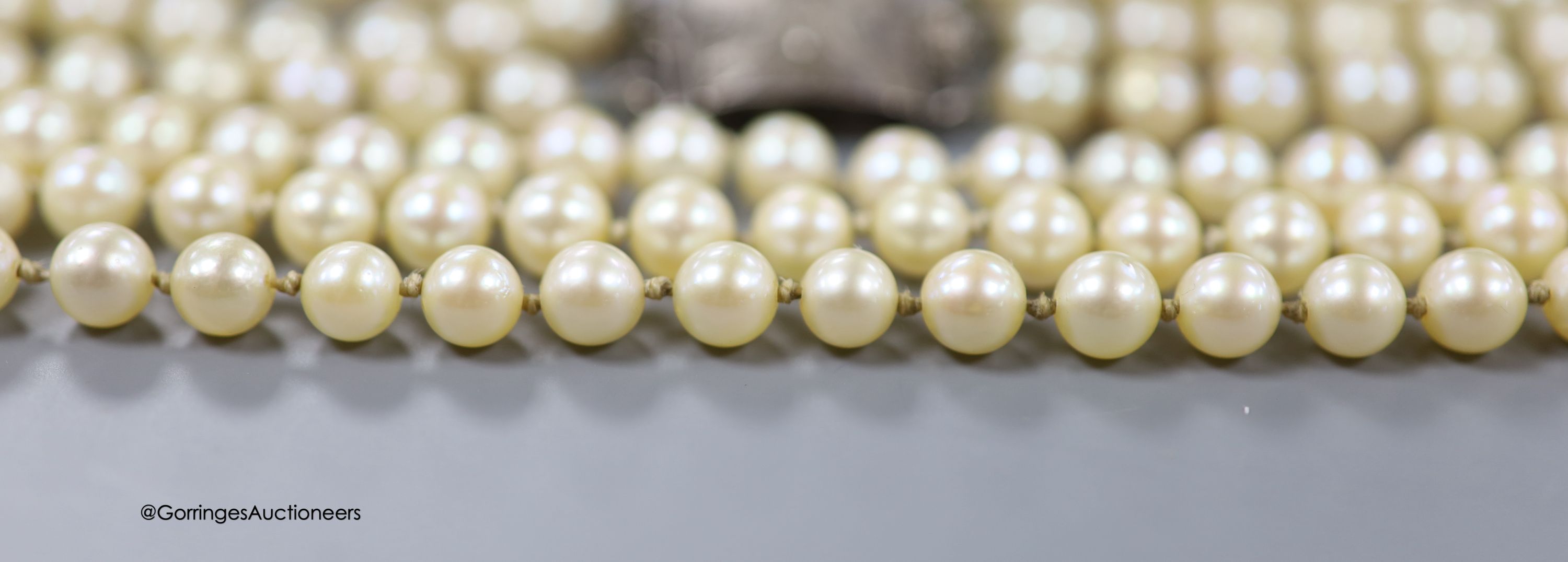 A triple strand cultured pearl choker necklace with white metal clasp, stamped 'silver', 41cm.